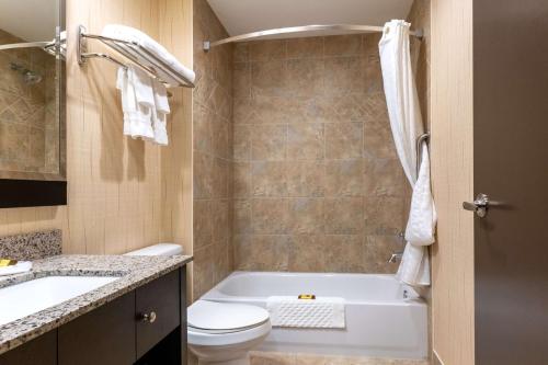 a bathroom with a tub and a toilet and a sink at Best Western Plus South Edmonton Inn & Suites in Edmonton