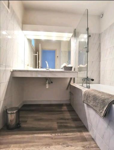 une salle de bain avec un lavabo, une baignoire et un miroir dans l'établissement Les quatre loges n°2, à Aix-en-Provence