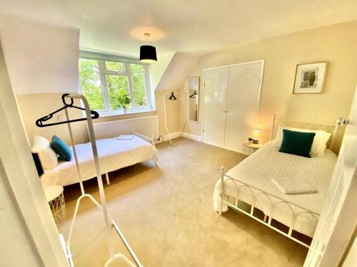 a bedroom with two beds and a window at EasyRest - Spacious Detached House - 10 Beds - 5 Bedrooms - 4 Bathrooms - Secure Parking 5 Vehicles - Excellent Road Links - Perfect for Contractors & Large Groups in Grantham