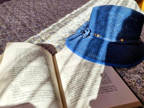 un sombrero azul sentado encima de un libro en Evaggelia's Apartments 5 Οικογενειακό Διαμέρισμα, en Kozani