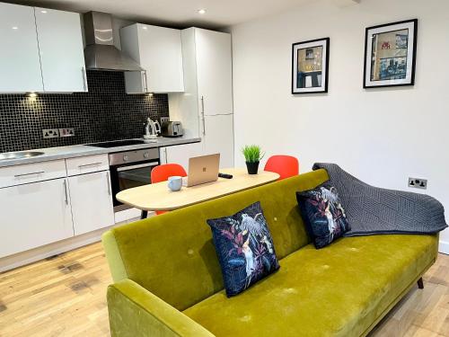 een woonkamer met een bank en een tafel met een laptop bij Palmer Apartment, 3 guests, Free Wifi, Great Transport Links, close to Uni, Hospital & Town Centre in Reading