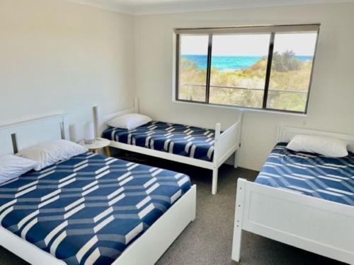 een slaapkamer met twee bedden en een raam bij Oceancrest 15 in Forster