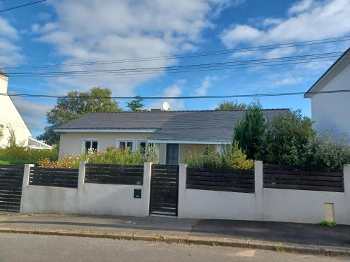 ein Haus mit einem weißen Zaun in der Unterkunft Studio privé avec terrasse entrée indépendante in Saint-Nazaire