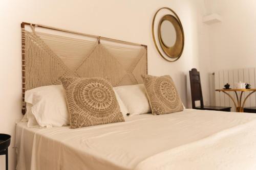 een bed met witte lakens en kussens in een slaapkamer bij Zahra Superior Suite with private pool in Sannicola