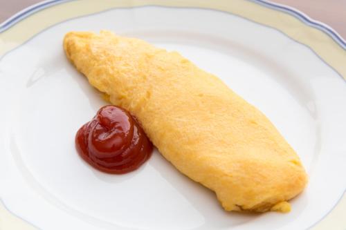 a white plate with a hot dog and ketchup at Hotel Crystal Palace in Hitachinaka