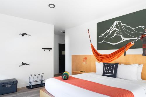 a bedroom with a bed with a hammock above it at LOGE Leavenworth Downtown in Leavenworth