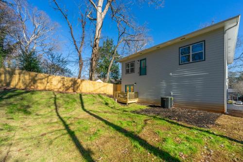a house with a fence next to a yard at Family Friendly New Luxury Home Centrally located in Atlanta