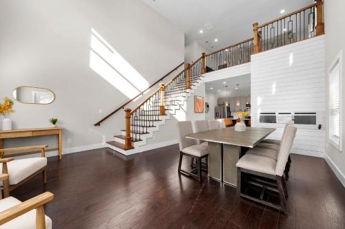 a dining room with a table and chairs and stairs at Family Friendly New Luxury Home Centrally located in Atlanta