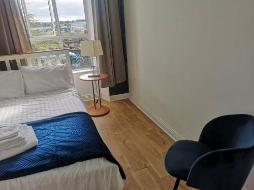 a bedroom with a bed and a chair and a window at Perfect apartment - close to the train station in Cork