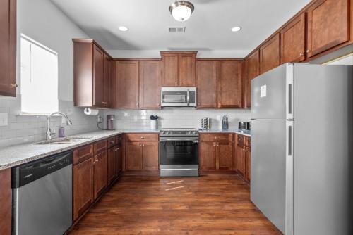 a kitchen with wooden cabinets and stainless steel appliances at Quiet Oasis in Lawrenceville
