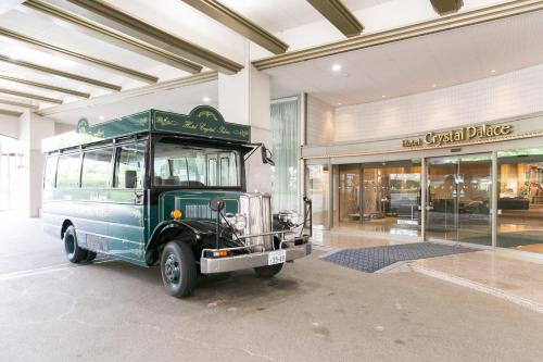 a green bus parked in front of a building at Hotel Crystal Palace in Hitachinaka