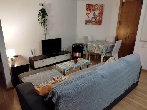 uma sala de estar com um sofá azul e uma mesa em Precioso Apartamento en Baiona Zona Centro em Baiona