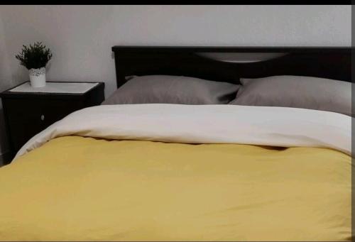 a bed with a yellow and white blanket and pillows at Evaggelia's Apartments 3 Διαμονή στο χωριό 