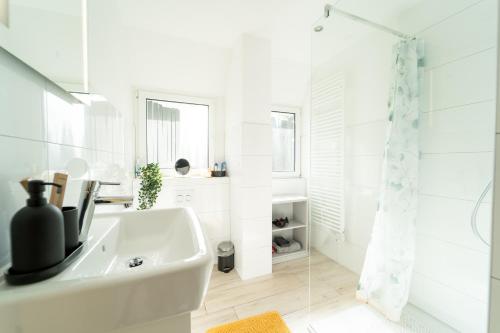 a white bathroom with a sink and a shower at Charmante Stadtwohnung in Essen