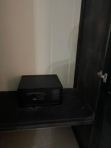 a microwave sitting on a black shelf in a room at hotel plaza BRISAS MT in Punta Cana