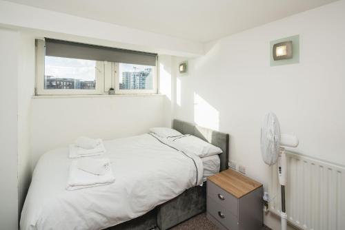 WoolwichにあるStunning 2-Bd Flat in Woolwichの白いベッドルーム(ベッド1台、窓付)