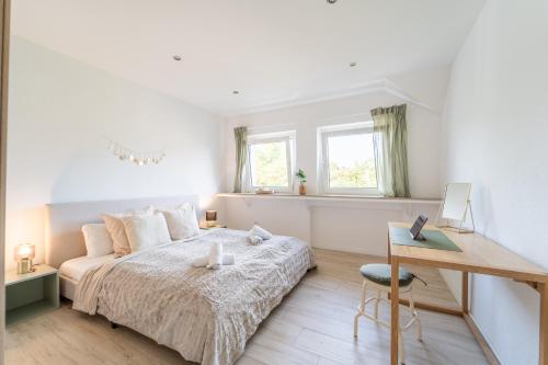 een witte slaapkamer met een bed en een bureau bij Charmante Stadtwohnung in Essen