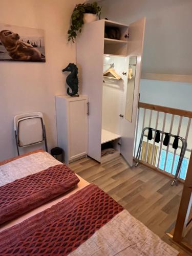 デン・ブルグにあるThuis op Texelのベッドルーム1室(ベッド1台付)、キャビネット上の猫1匹