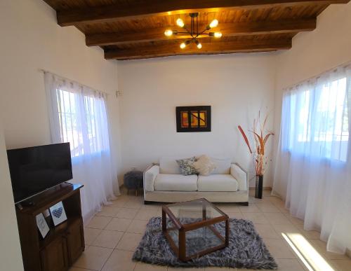 een woonkamer met een bank en een tv bij Departamento Alto Malbec in La Cieneguita