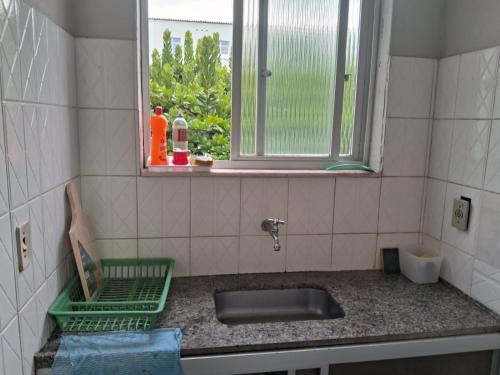 um balcão de cozinha com um lavatório e uma janela em Apartamento em Jacaraipe ES 3 quartos em Jacaraípe