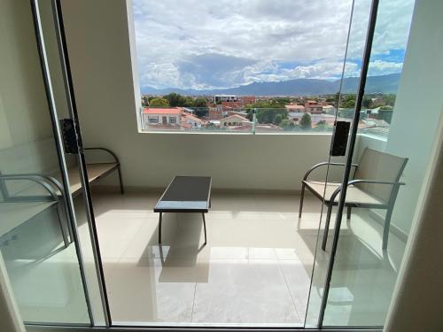 Zimmer mit einem Tisch, 2 Stühlen und einem Fenster in der Unterkunft Departamento tres dormitorios in Tarija