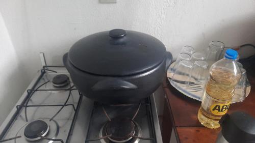a black pot on a stove with some water bottles at Apartamento em Jacaraipe ES 3 quartos in Jacaraípe