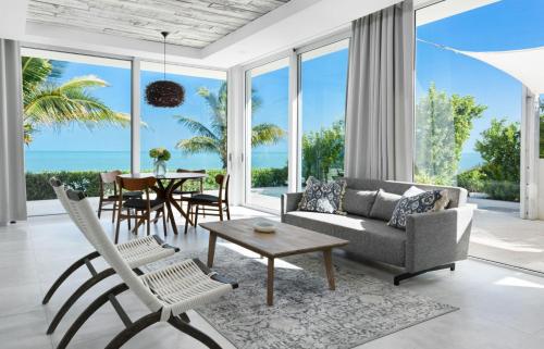 a living room with a couch and chairs and a table at Ocean Dream 5 BR Villa Aqua in Long Bay Hills