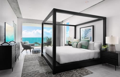 a bedroom with a large bed with a view of the ocean at Ocean Dream 5 BR Villa Aqua in Long Bay Hills