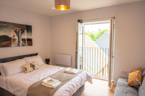 een slaapkamer met een bed en een glazen schuifdeur bij Apartment by the Royal Ramsgate Harbour - Sleeps 4 in Kent