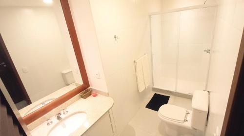 a bathroom with a sink and a toilet and a mirror at Lindo Apartamento Moderno e Reformado na Barra in Rio de Janeiro
