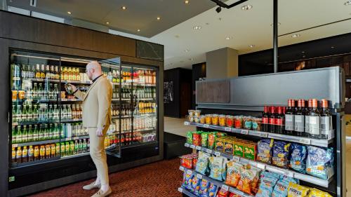 a mannequin standing in front of a supermarket refrigerator at Crowne Plaza Amsterdam - South by IHG in Amsterdam