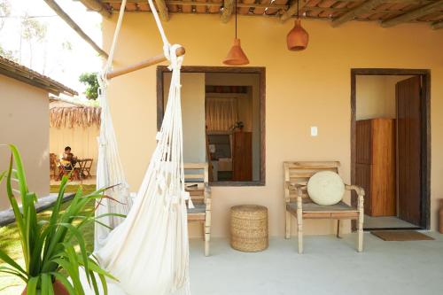 a porch with a hammock and a table at Evoé Caraíva in Caraíva