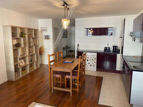 a kitchen and dining room with a table and chairs at Charmant T2 in Rives