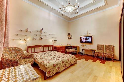 Schlafzimmer mit einem Bett, einem Schreibtisch und einem TV in der Unterkunft Longo Apartment Kirochnaya 27 in Sankt Petersburg