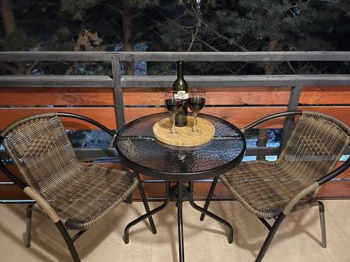 a table with two chairs and a glass of wine at 20%off to Bakuriani amenities in Bakuriani