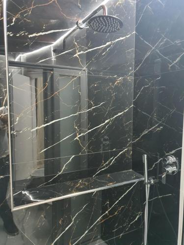 a bathroom with a black marble shower with a mirror at Sweet Dream in Caserta