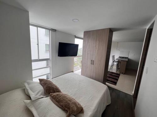 una camera da letto con un letto con due cuscini e una TV di Urban Manizales 603 a Manizales