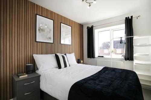 a bedroom with a large bed and a window at Large 4 Bed House - Long Stays Welcome - Smart TVs in Each Bedroom - Parking - Wifi in Peterborough