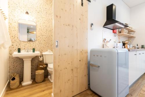 a kitchen with a refrigerator and a sink at Amália Boutique Suites & Studios - by @ rita´s place in Faro