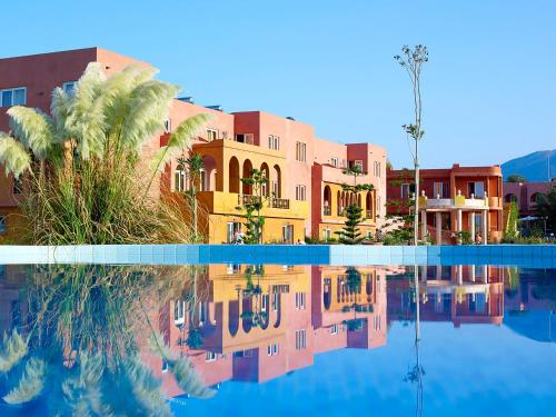 a resort with a pool of water and palm trees at Orpheas Resort Hotel (Adults Only) in Georgioupolis