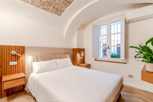 a bedroom with a white bed and a window at Parco Ducale Design Rooms in Parma