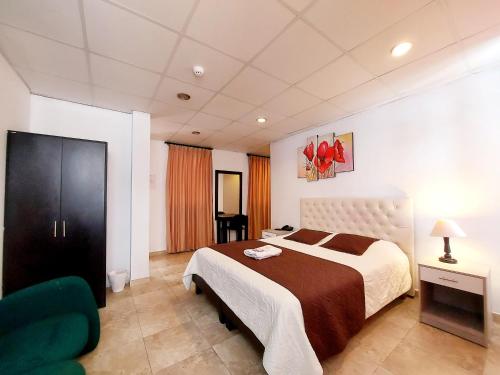 1 dormitorio con 1 cama grande y 1 silla verde en HOSTAL MURGEON BOUTIQUE, en Quito