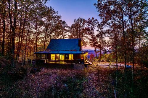 a small cabin in the woods with a blue roof at King Beds, VIEWS, Fire Pit, Spa, No Fees, New, Private, Games in Sevierville
