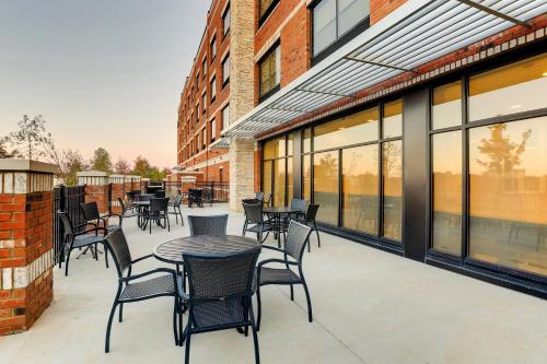 a patio with tables and chairs and windows at Holiday Inn Express Holly Springs - Raleigh Area by IHG in Holly Springs