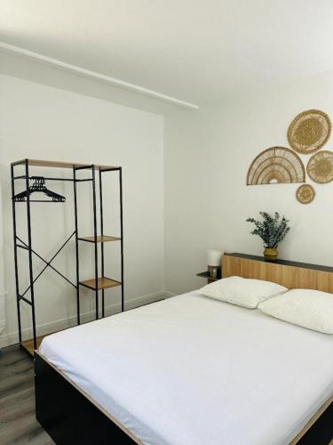 a bedroom with a white bed and a shelf at SAB Location - Appartement in Ducos