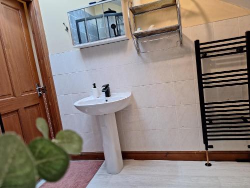 a bathroom with a white sink and a mirror at Another sweet home in Bradford
