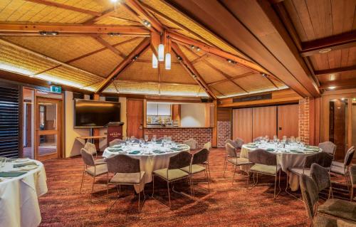 a conference room with tables and chairs and a television at Arkaba Hotel in Adelaide