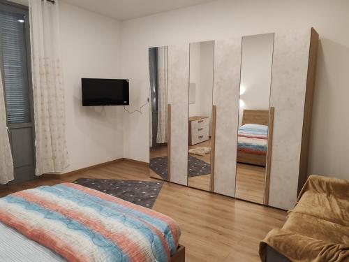a bedroom with a mirror and a bed and a tv at Appartamenti Lungo Fiume 506 in Sesto Calende