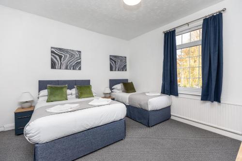 una camera con due letti e una finestra di Spacious three bedroom property! a Hemsworth
