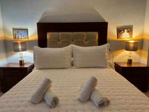 een slaapkamer met een groot bed en 2 handdoeken bij Apartamento Buen Pastor con parking gratuito in Córdoba